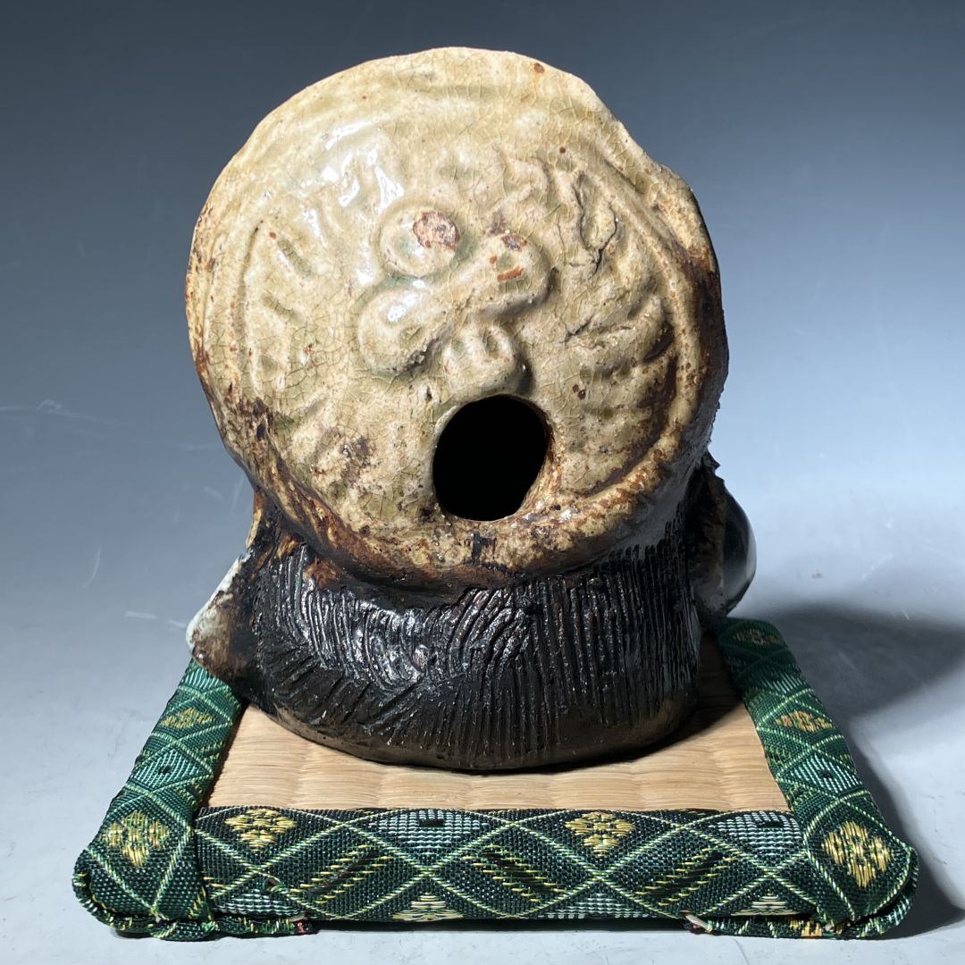 Ceramic object with intricate design on a textured surface