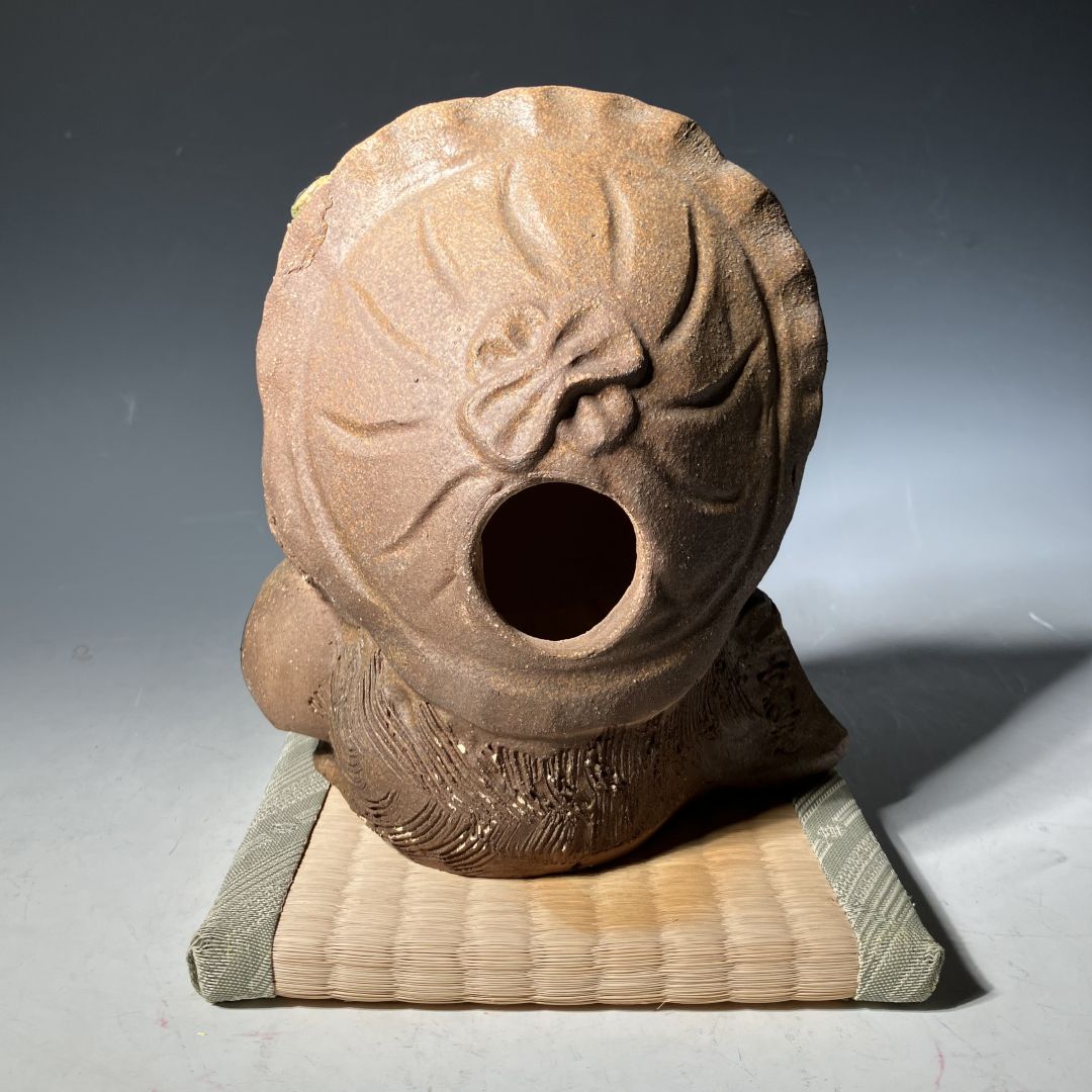 Decorative stone object with floral design on a textured surface