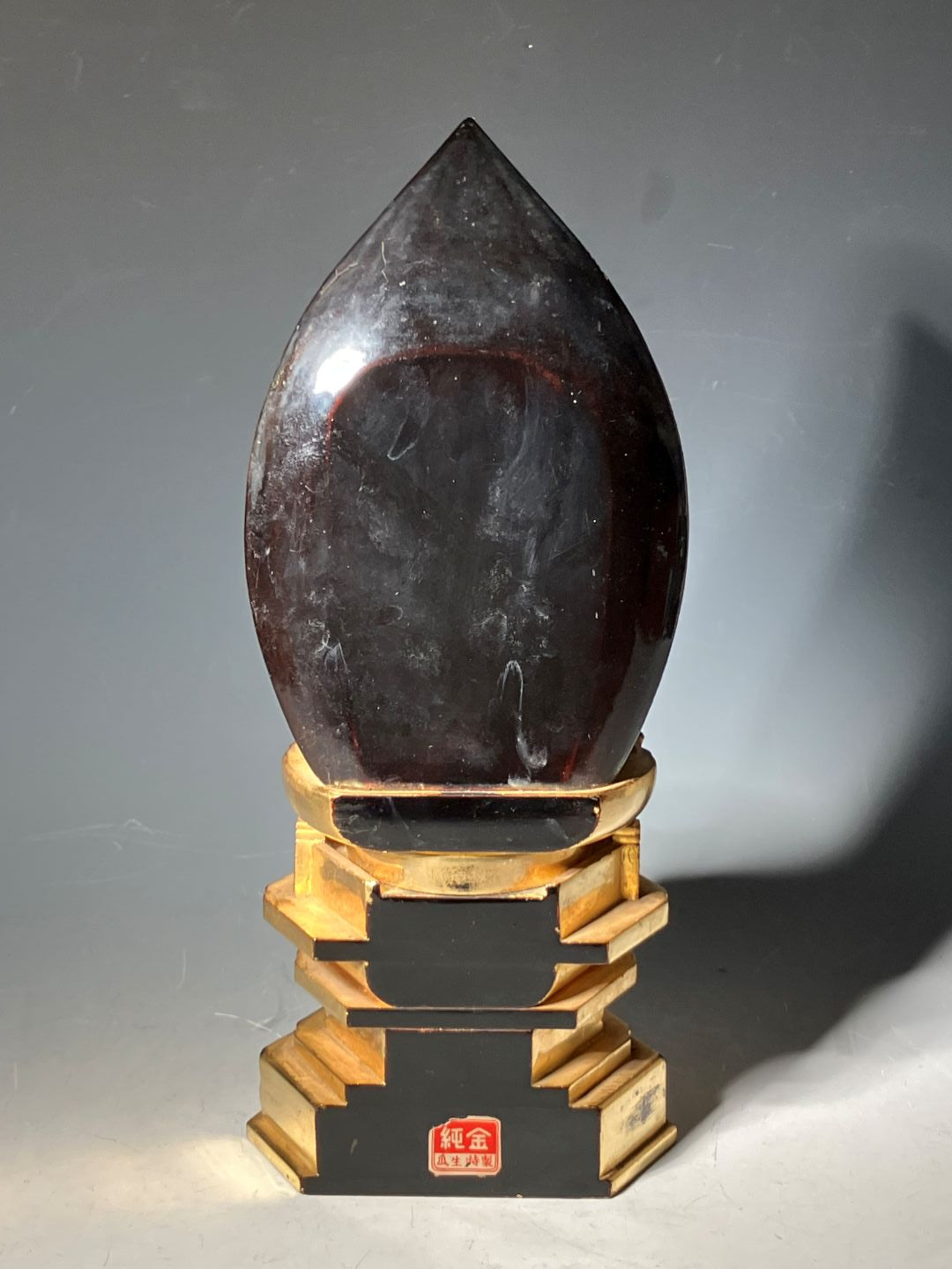 Wooden tool with a dark stone blade on a gray background
