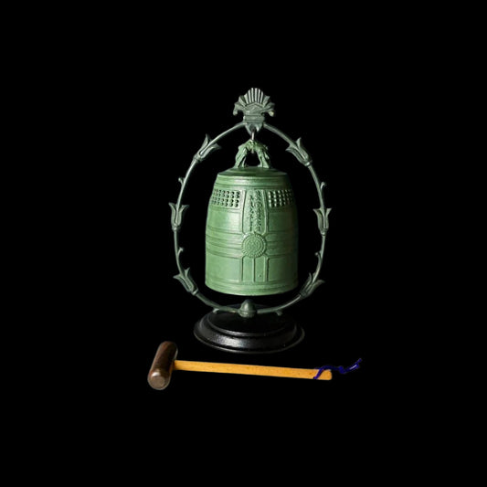 Japanese vintage metal gong with a bronze finish, mounted on a wooden stand, accompanied by a wooden stick with a yellow tip.