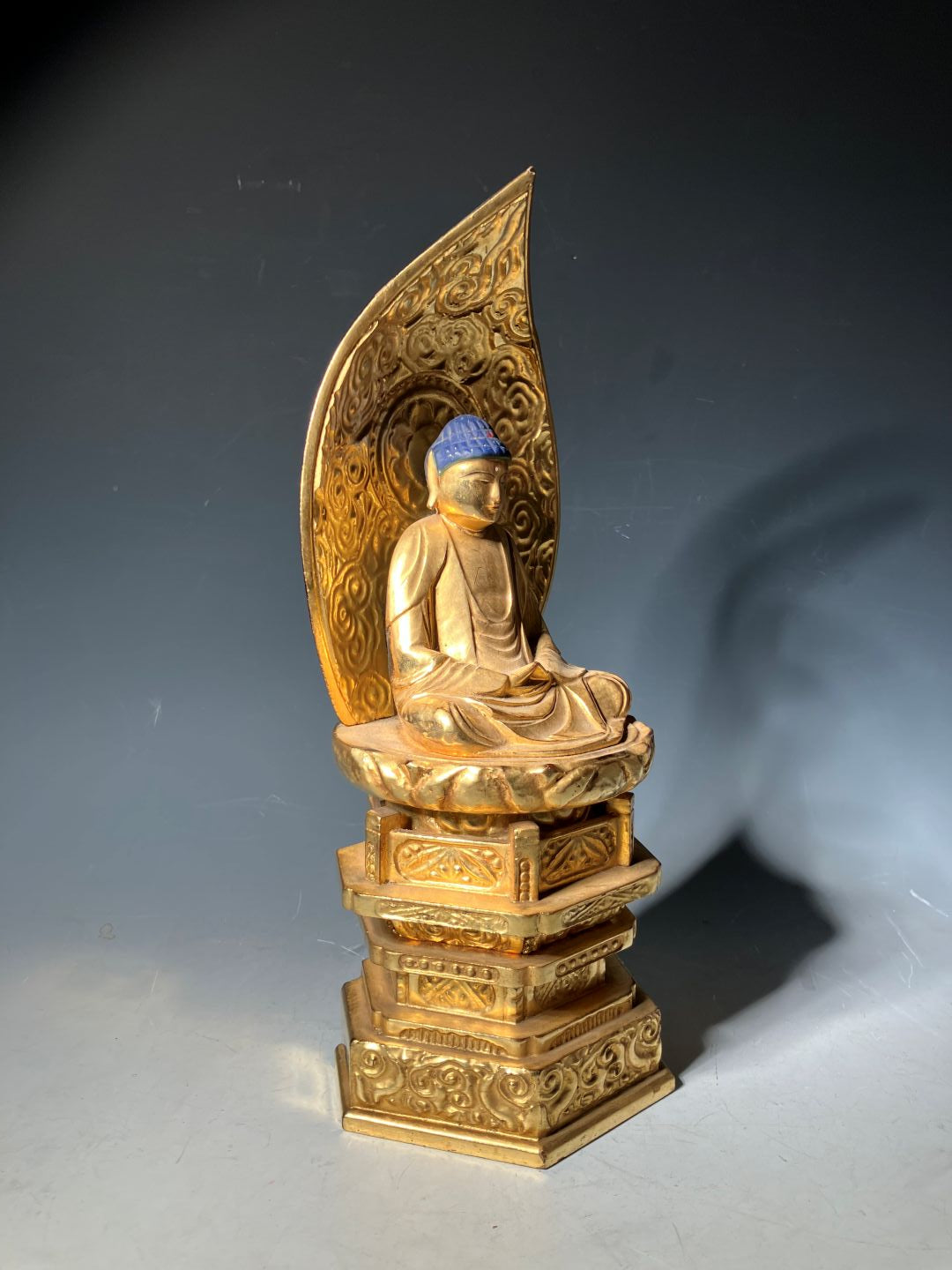 Gold-colored decorative object on a reflective surface