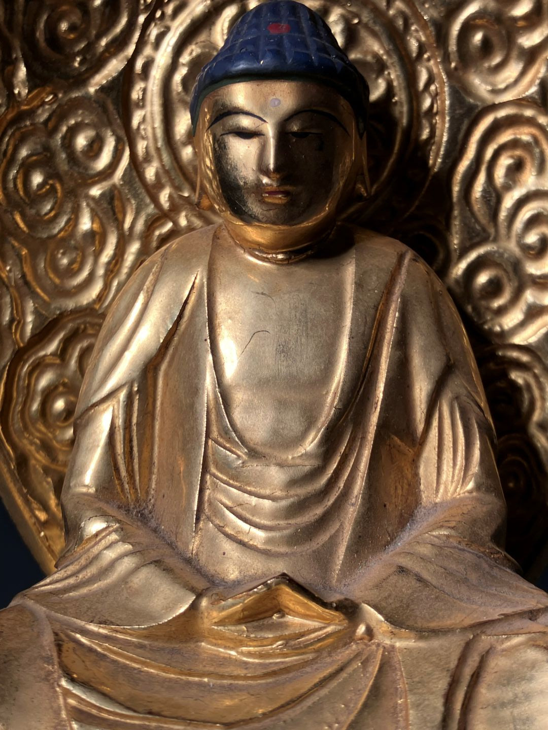 Close-up of a gold Buddha statue with intricate patterns
