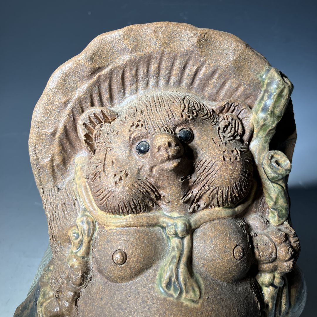 Ceramic bear figurine with a decorative background
