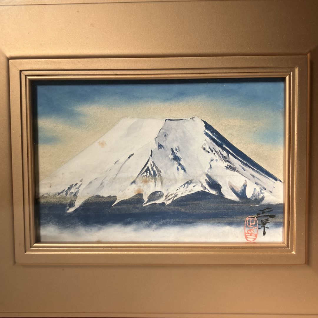 Framed artwork of a mountain landscape with a gold frame