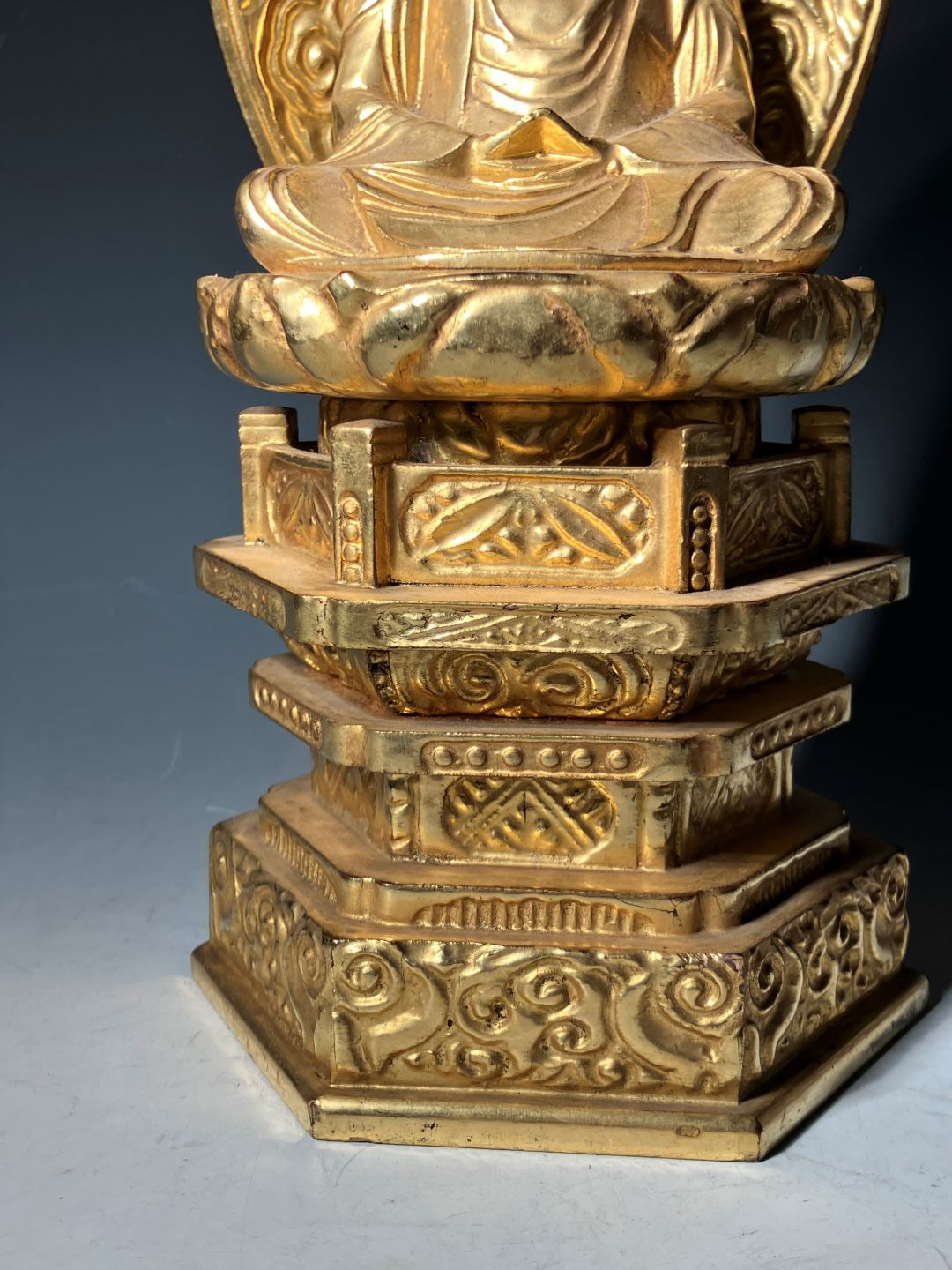 Decorative gold object with intricate patterns on a blue and gray background