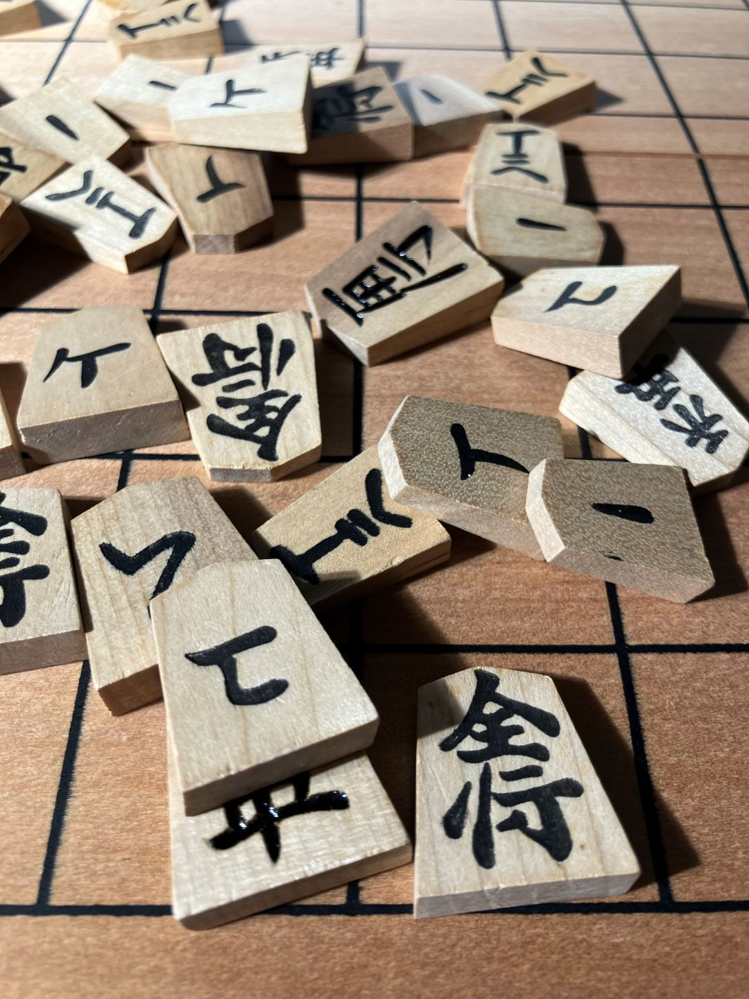 Wooden tiles with Chinese characters scattered on a checkered surface