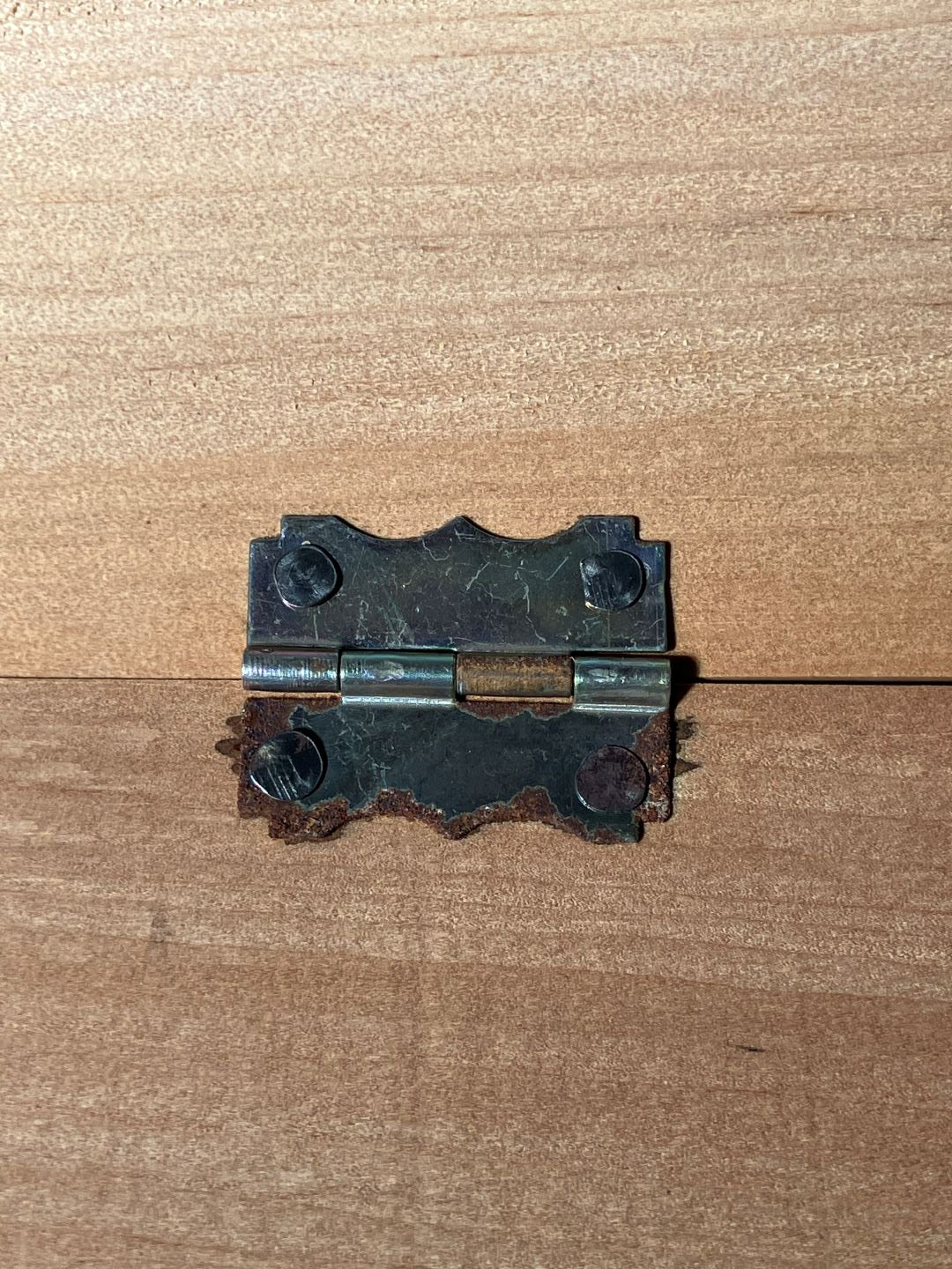 Metallic hinge on a wooden surface