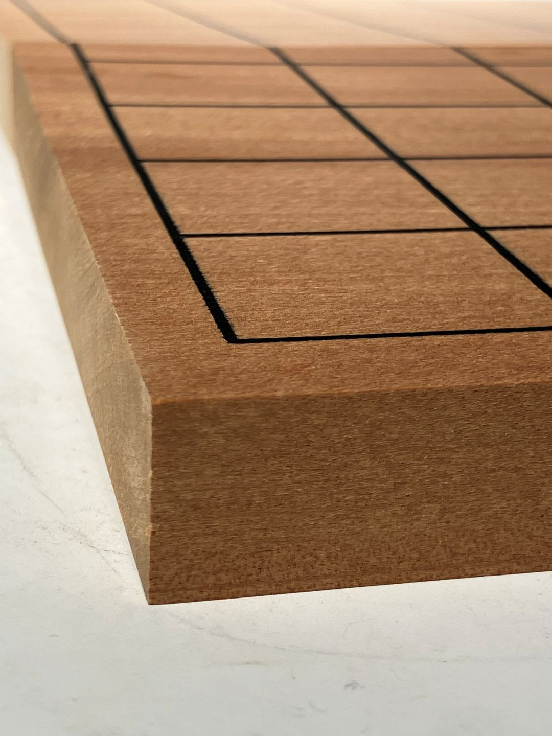 Close-up of a wooden panel with a geometric pattern on a white background
