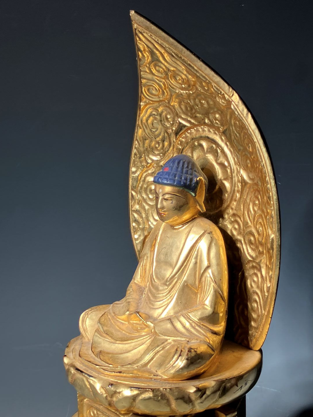Gold decorative object with intricate designs on a dark background