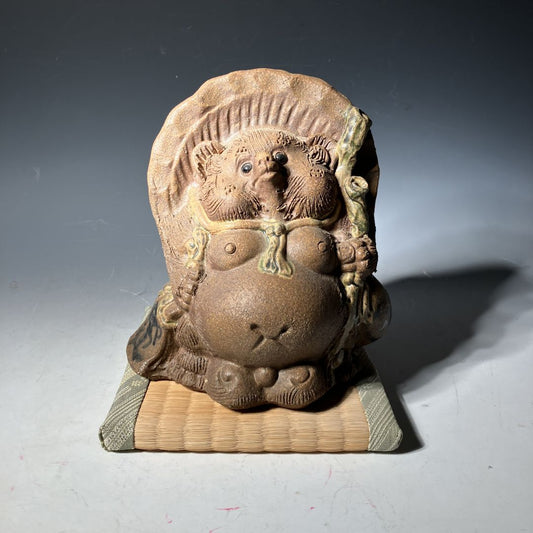 Ceramic sculpture of a stylized creature on a plain background