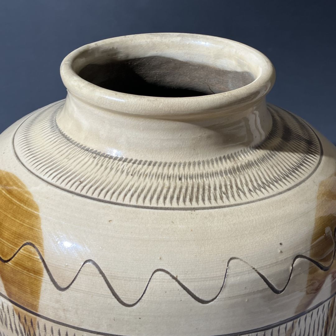 Ceramic jar with decorative patterns on a dark background