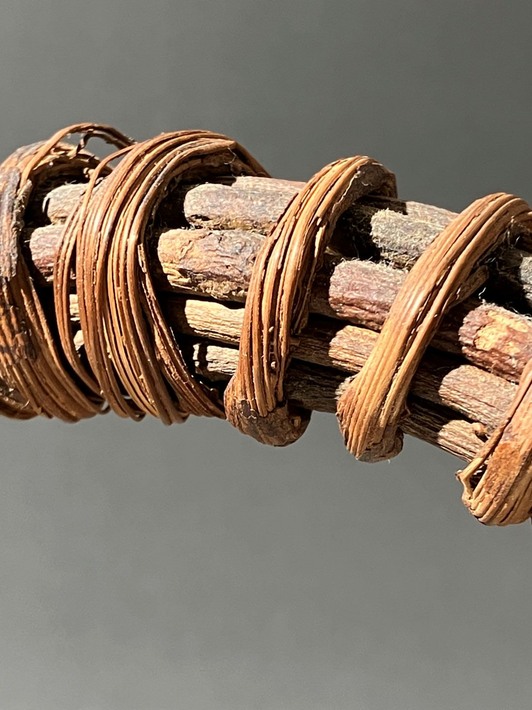Wooden spiral with braided copper wire on a gray background