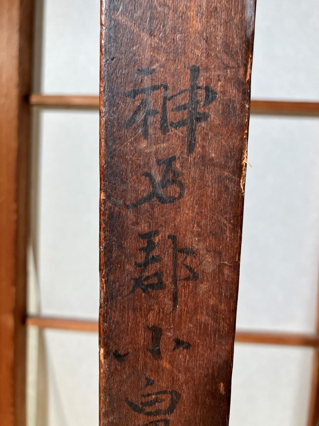 Wooden blade with engraved text on a white background
