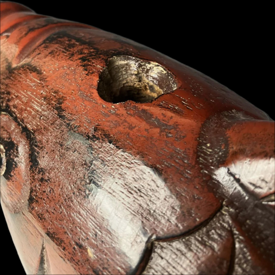 A close-up image showing the detailed tail section of an antique Japanese wooden fish carving. The surface has a lustrous, deep reddish-brown finish with visible wear and scuff marks that add character to the piece