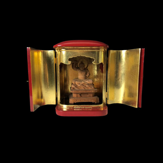 An open Japanese vintage Zushi cabinet displaying a 6.4-inch wooden sculpture of Myoken, the God of the Big Dipper, with a contrasting gold interior and red exterior.