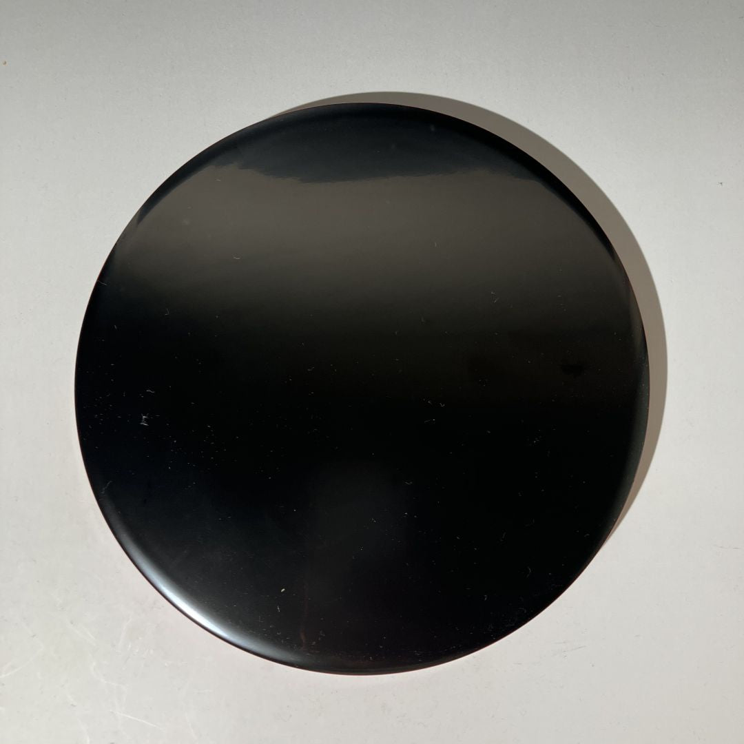 Black circular object on a gray background