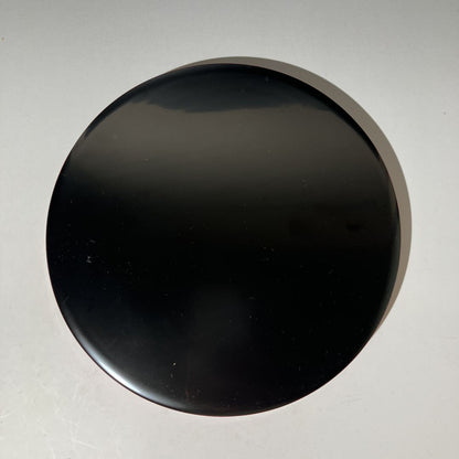 Black circular object on a gray background