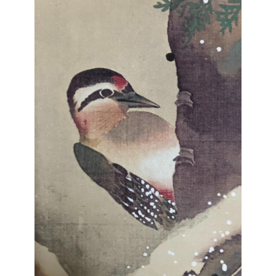 A close-up of a woodpecker with intricate plumage, as depicted on a traditional East Asian scroll painting, perched against a tree trunk.