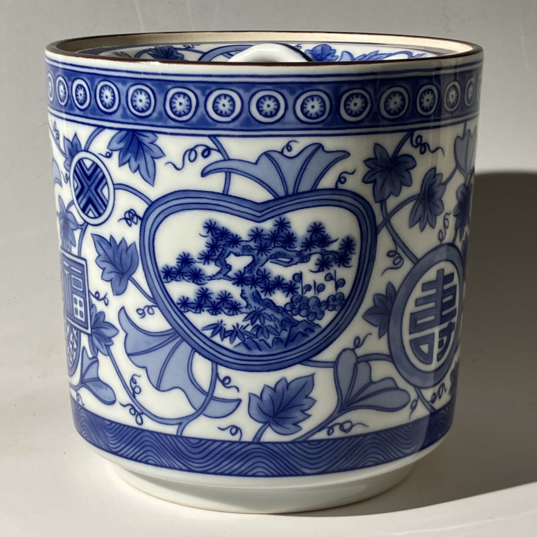 Blue and white ceramic mug with intricate patterns on a gray background