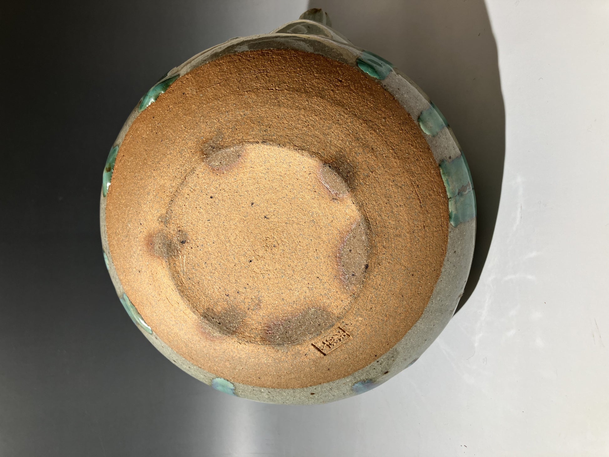 Close-up of a ceramic vase with a textured surface on a white background