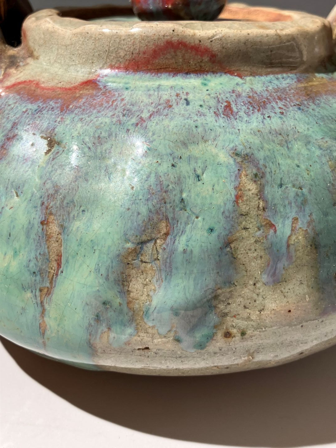 Close-up of a ceramic vase with textured surface and color variations