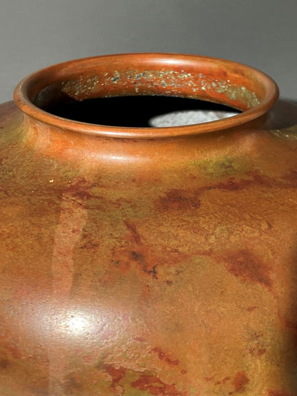 Close-up of a ceramic pot with a textured surface on a gray background