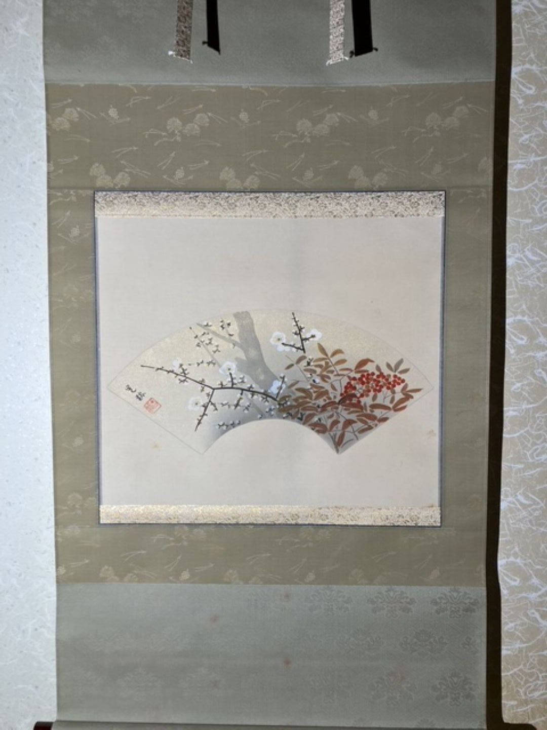 Framed artwork with a floral design on a textured wall.