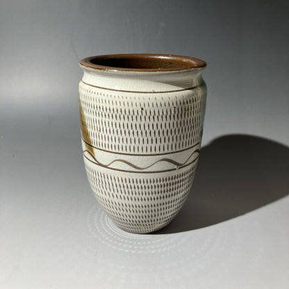 Ceramic vase with brown and white pattern on a gray background