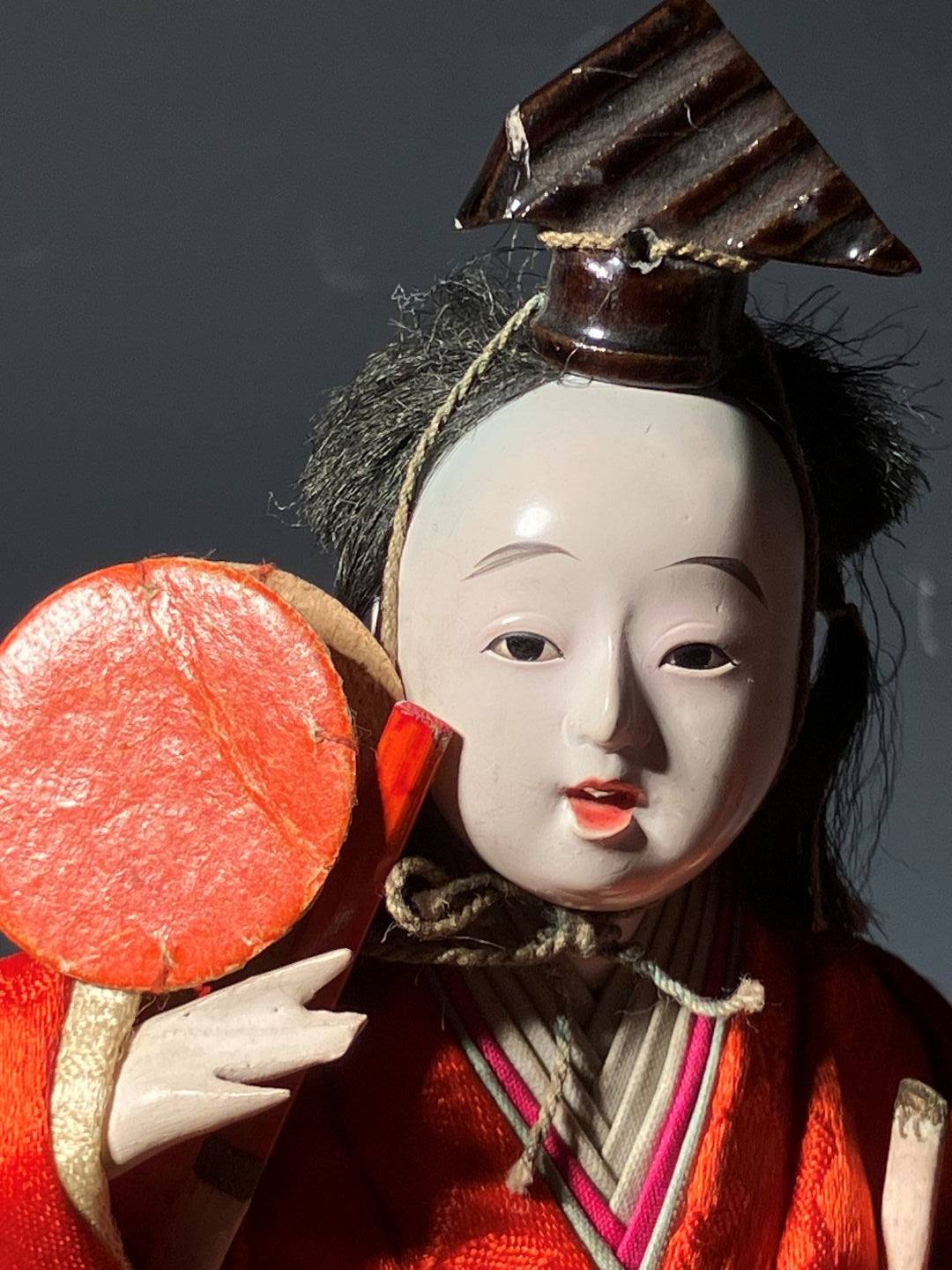 Close-up of a traditional doll with red and white clothing against a dark background