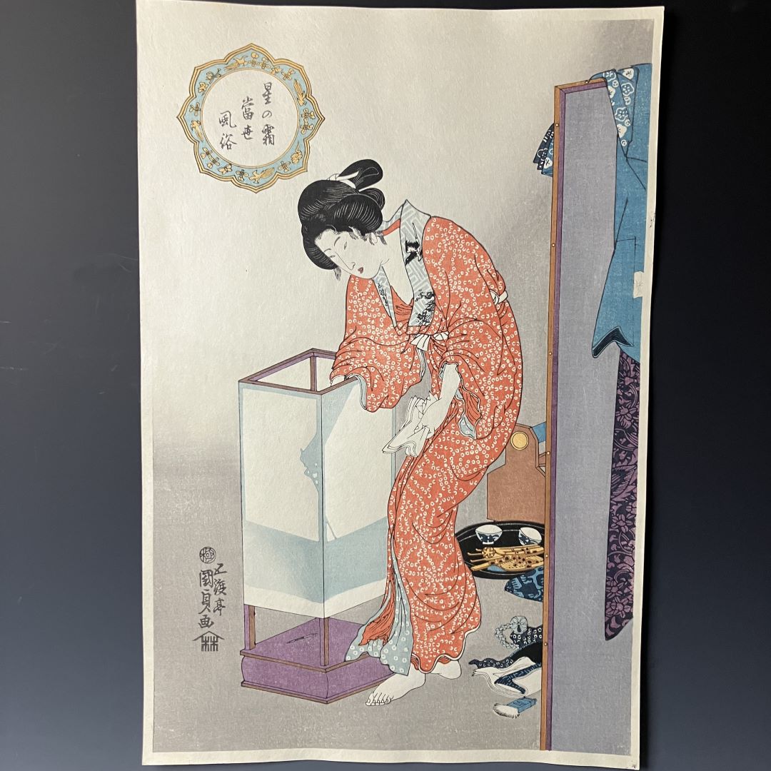 Traditional Japanese woodblock print of a woman in a kimono by a mirror.