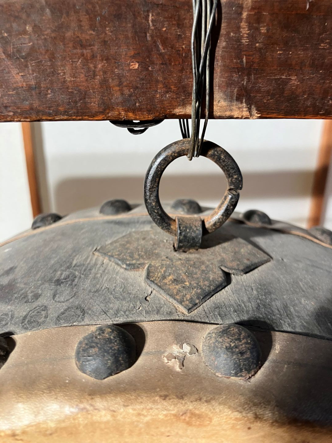 Close-up of a metal gear and wooden surface with visible wear.