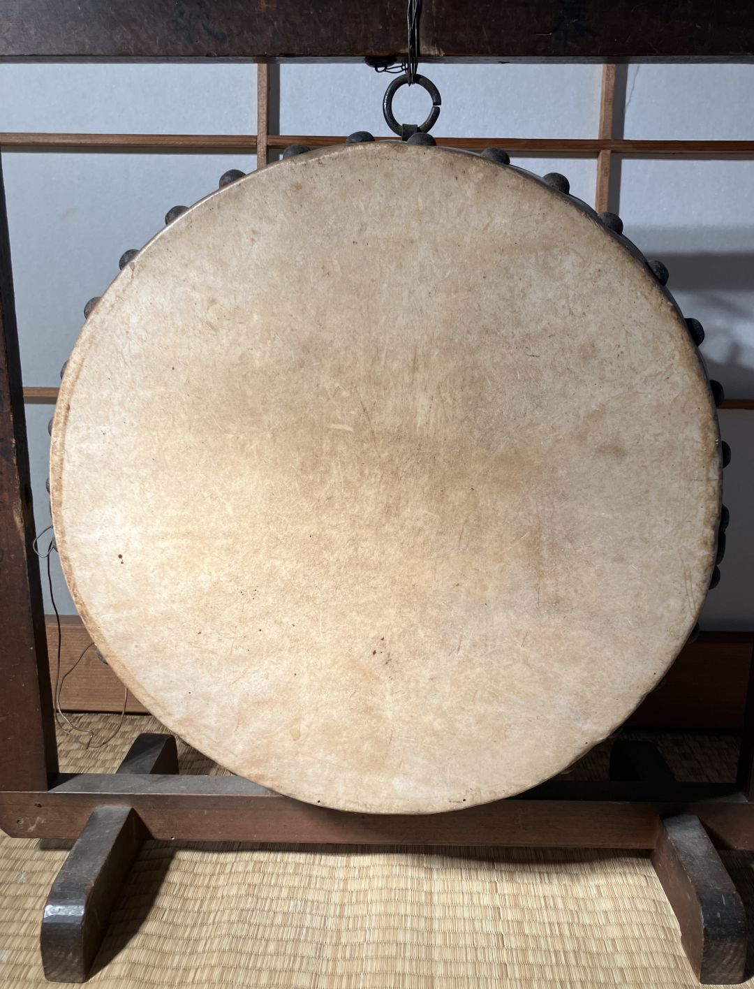 Traditional Japanese gong on a stand with a wooden frame in the background