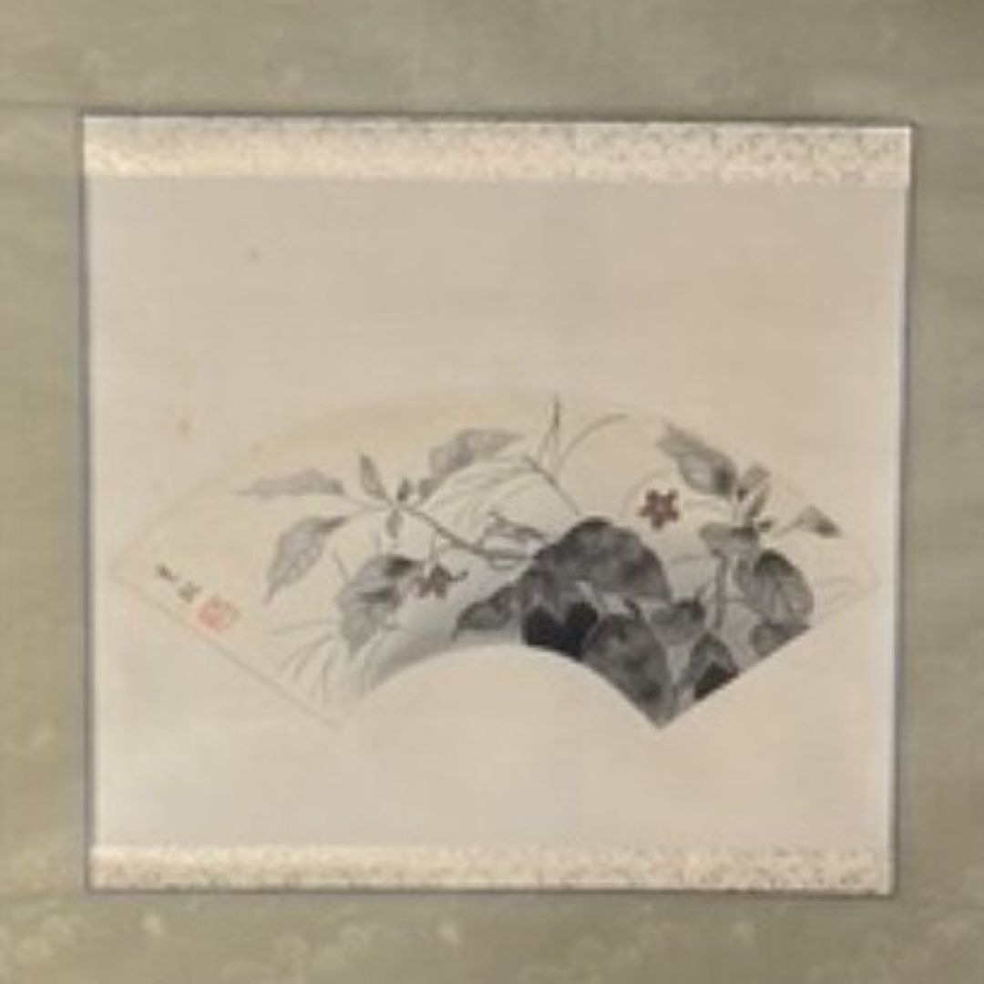 Framed artwork with a traditional design on a beige wall.