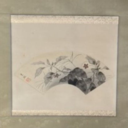 Framed artwork with a traditional design on a beige wall.