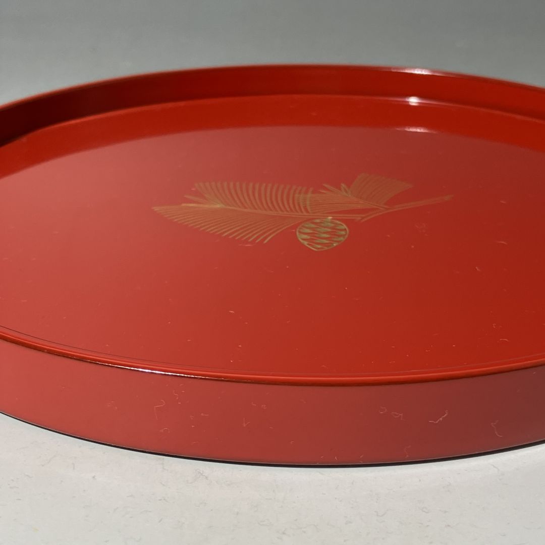 Red tray with gold leaf design on a gray background