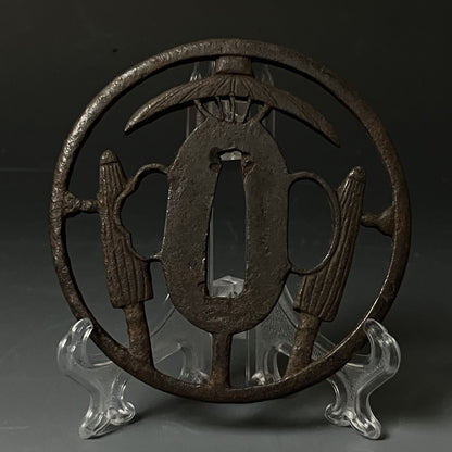 Decorative metal piece on a stand against a dark background