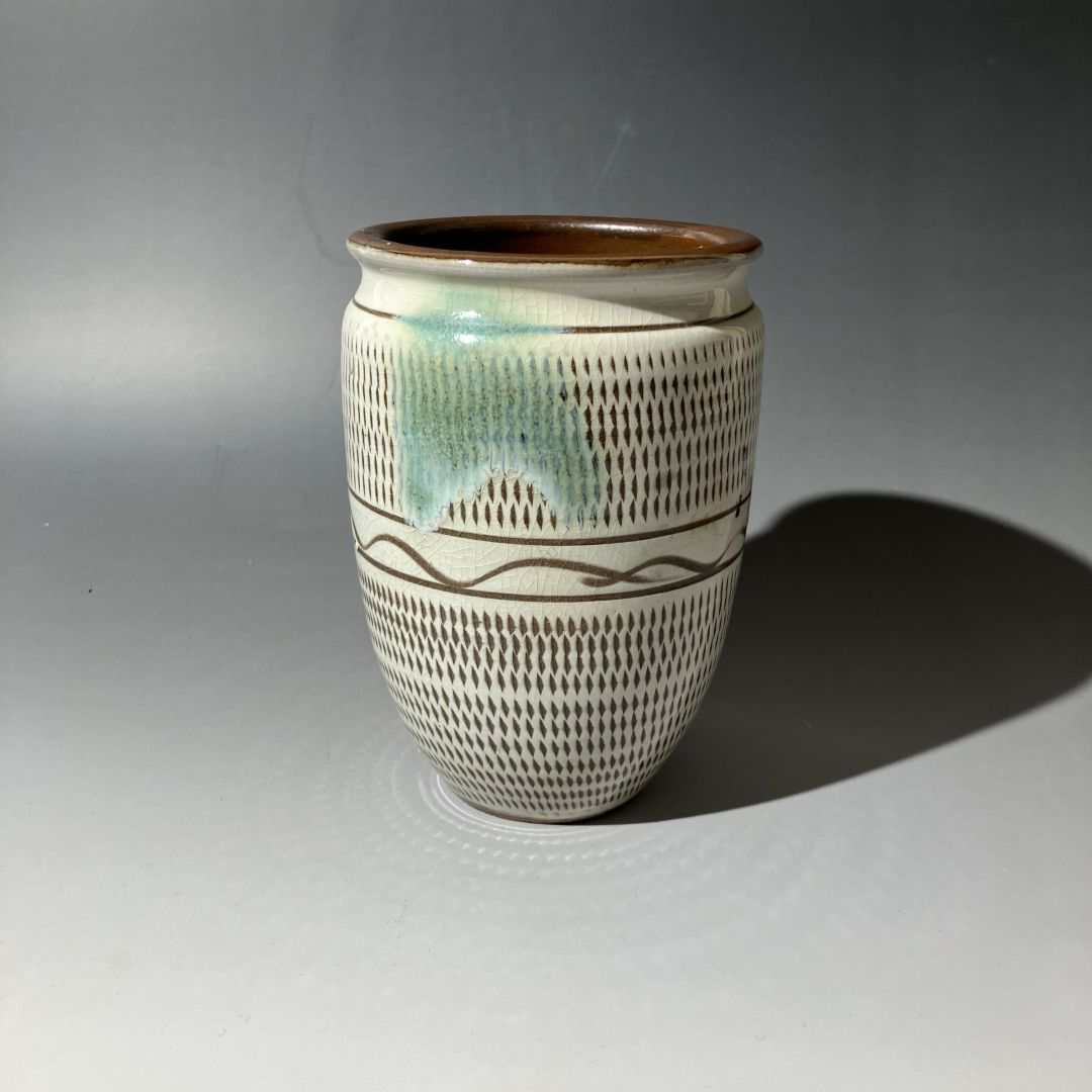 Ceramic vase with textured design on a gray background