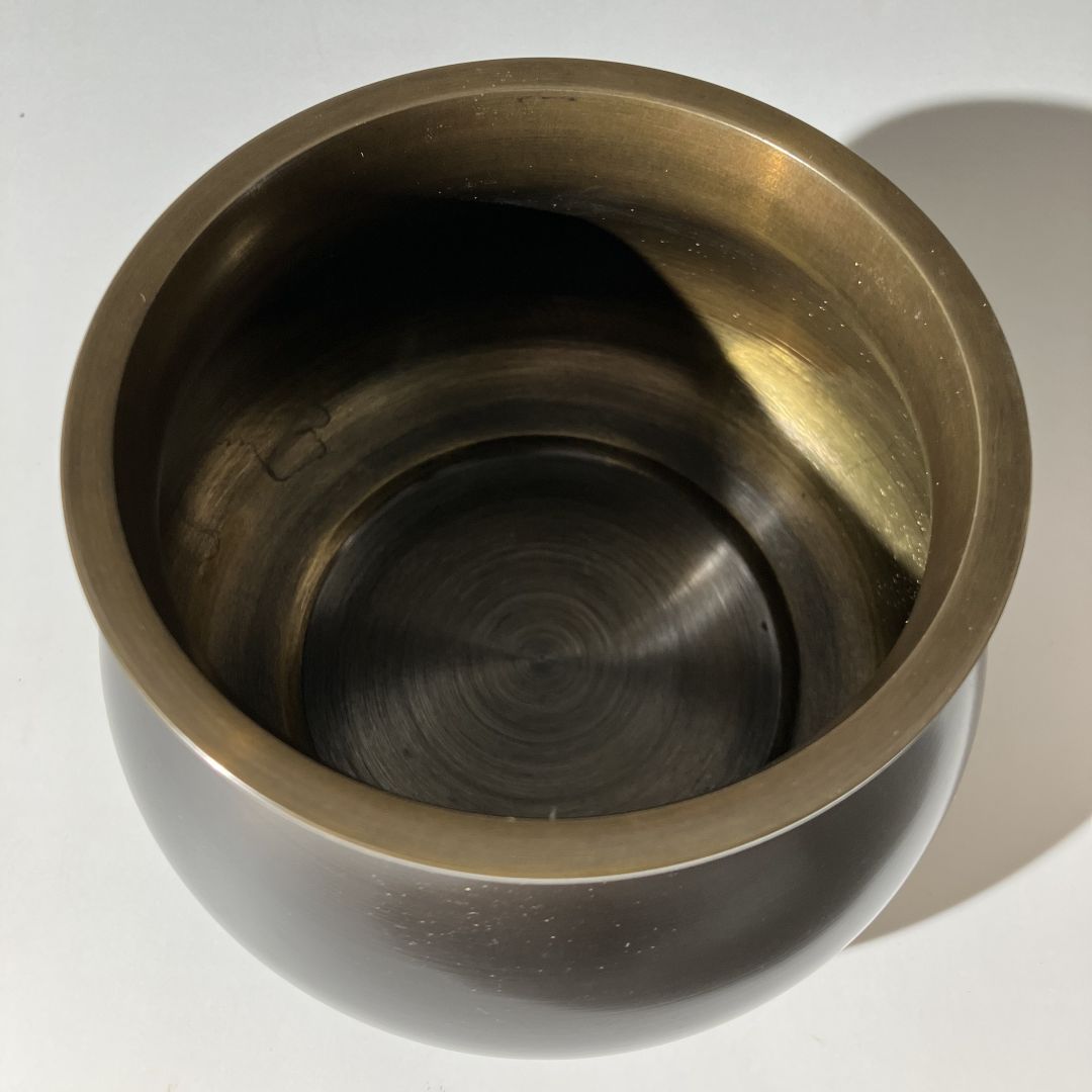 Bronze-colored metal cup on a white background