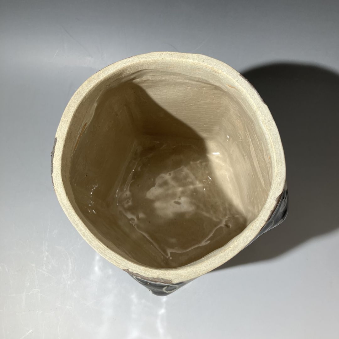 Close-up of a ceramic cup with a textured interior on a reflective surface