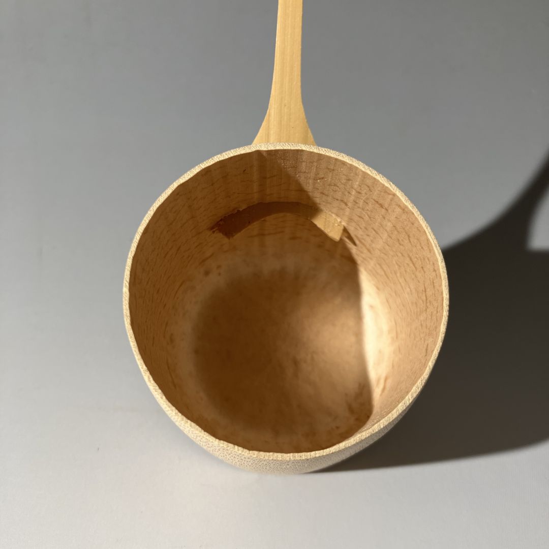 Wooden ladle on a gray background