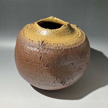 Ceramic vase with a textured surface on a gray background