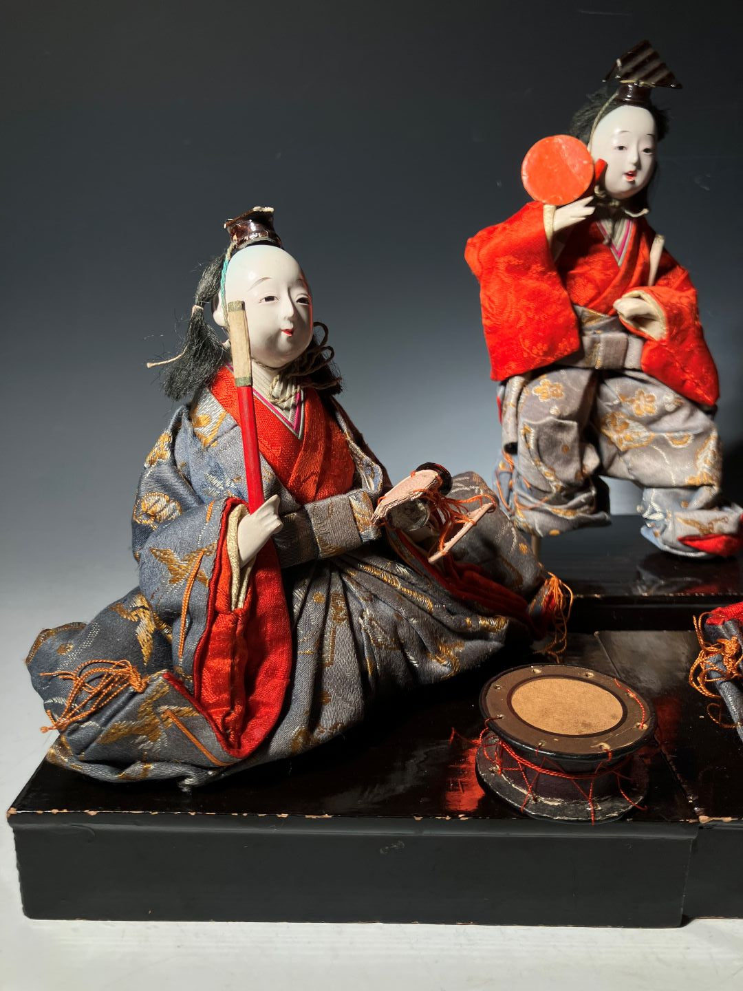 Traditional Japanese dolls in elaborate costumes on a dark background