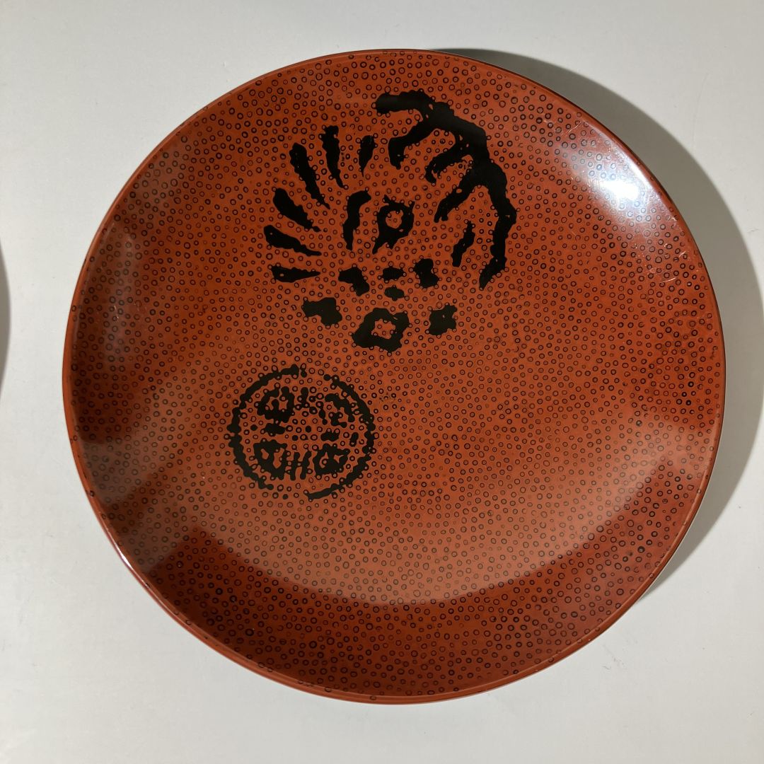 Brown ceramic plate with black textured design on a white background