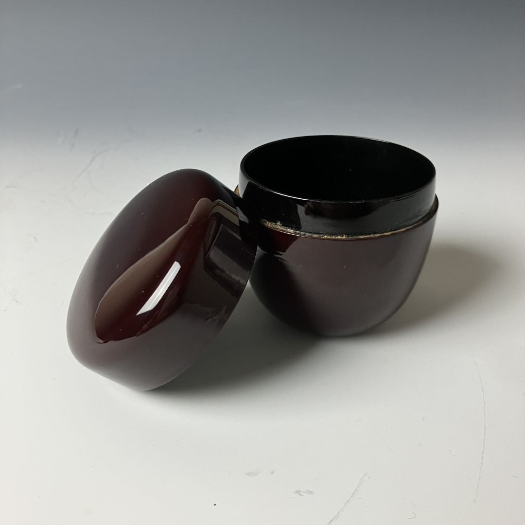An open 19th-century Japanese lacquered makie natsume tea caddy in deep brown, displaying its smooth finish and meticulous craftsmanship, exemplifying the elegance and tradition of Japanese tea ware.