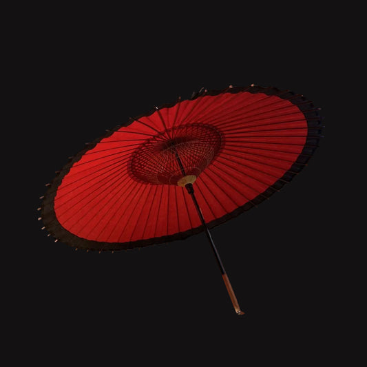 Red Japanese umbrella on a tatami mat floor with sliding doors in the background