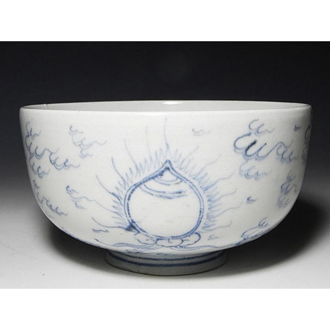 Antique Ko-Imari porcelain bowl with blue Buddhist motif design on a white background, featuring clouds and a central flame-like pattern, symbolizing spiritual enlightenment.