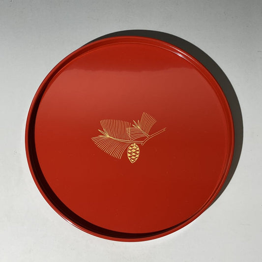 Red lid with a gold pine cone design on a gray background