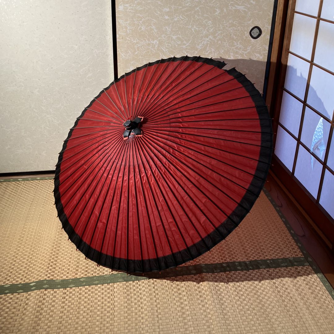 Traditional red and black umbrella on a tatami mat floor