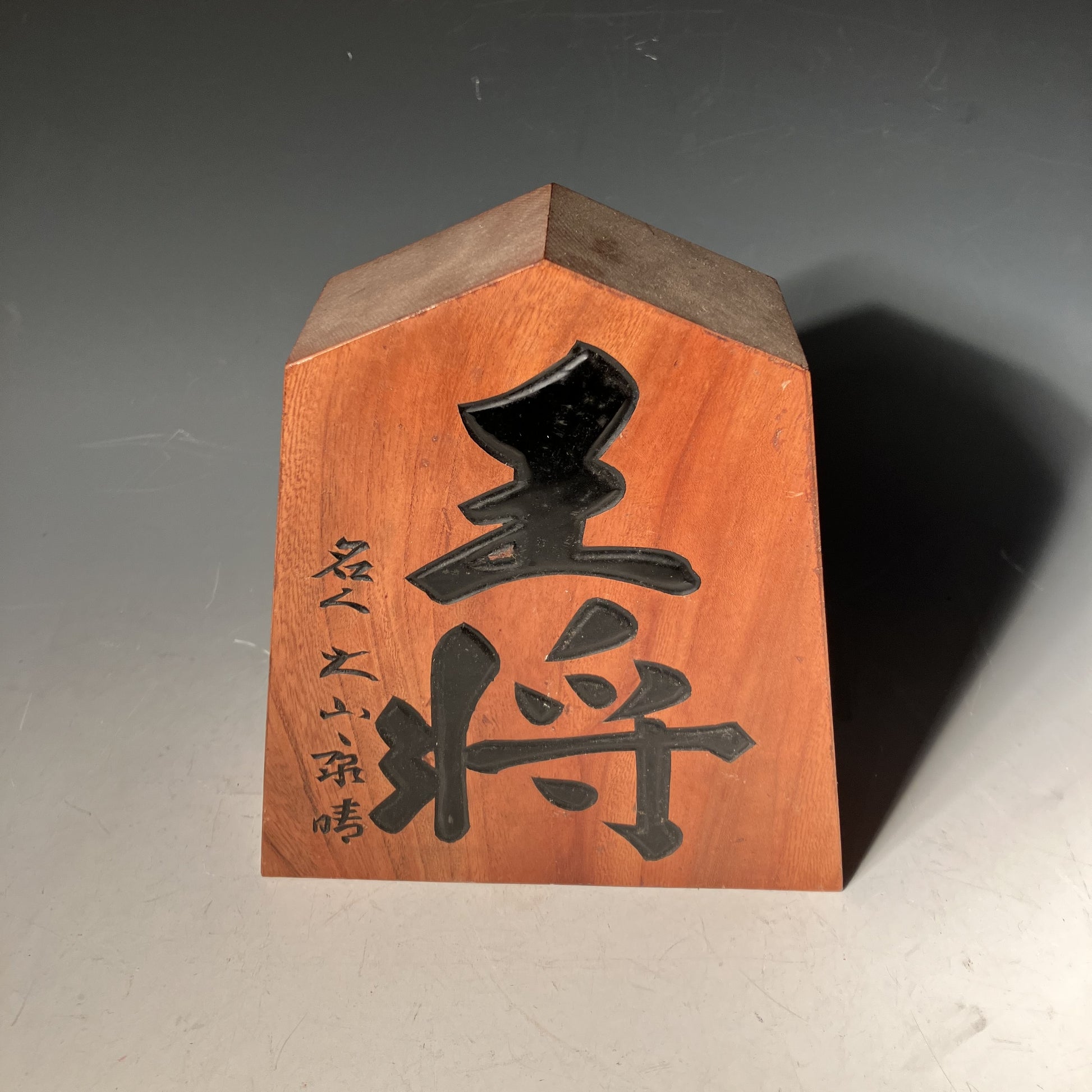 Wooden block with black characters on a gray background