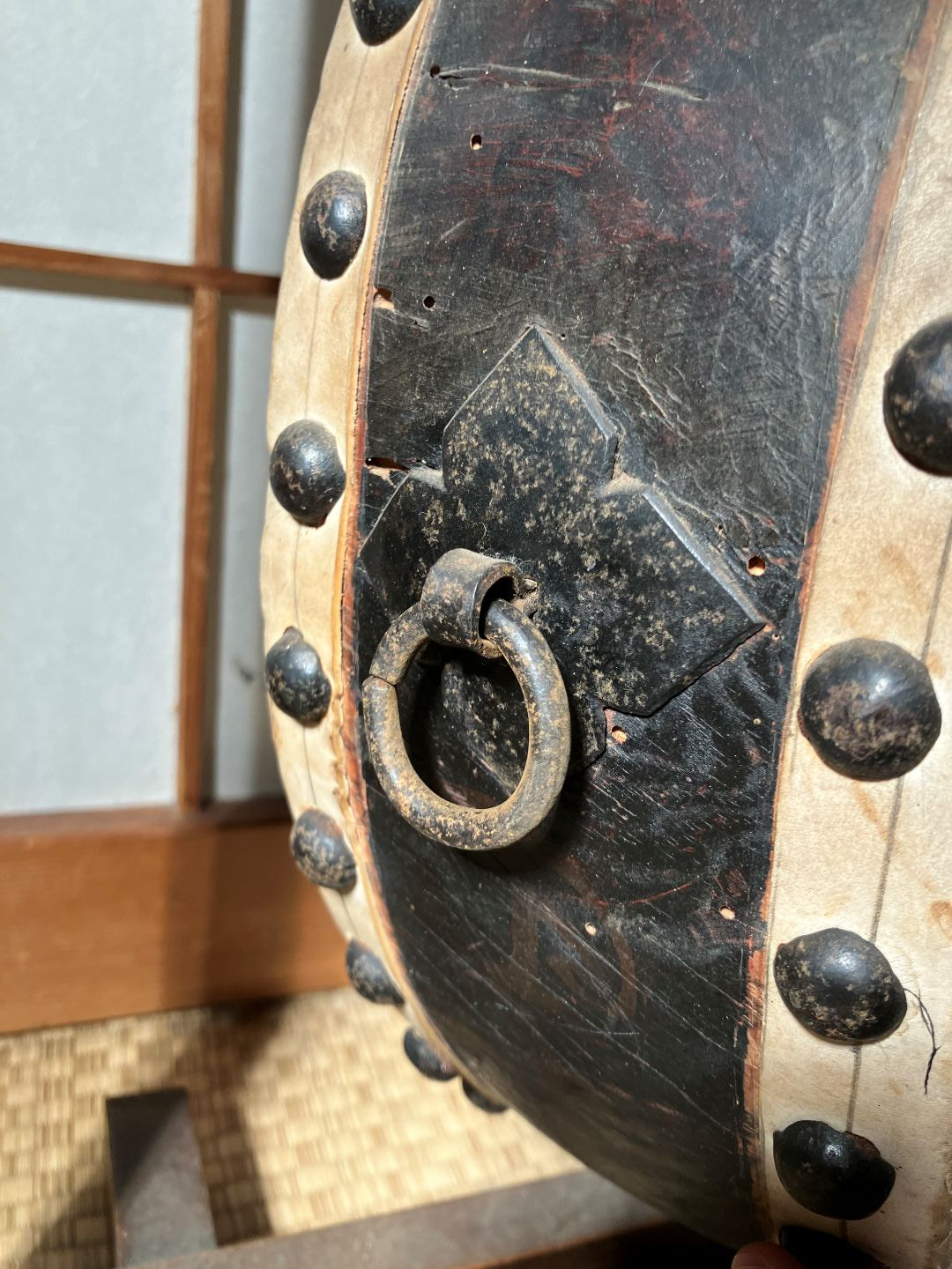 Close-up of a black leather-bound book with metal clasps on a wooden surface.